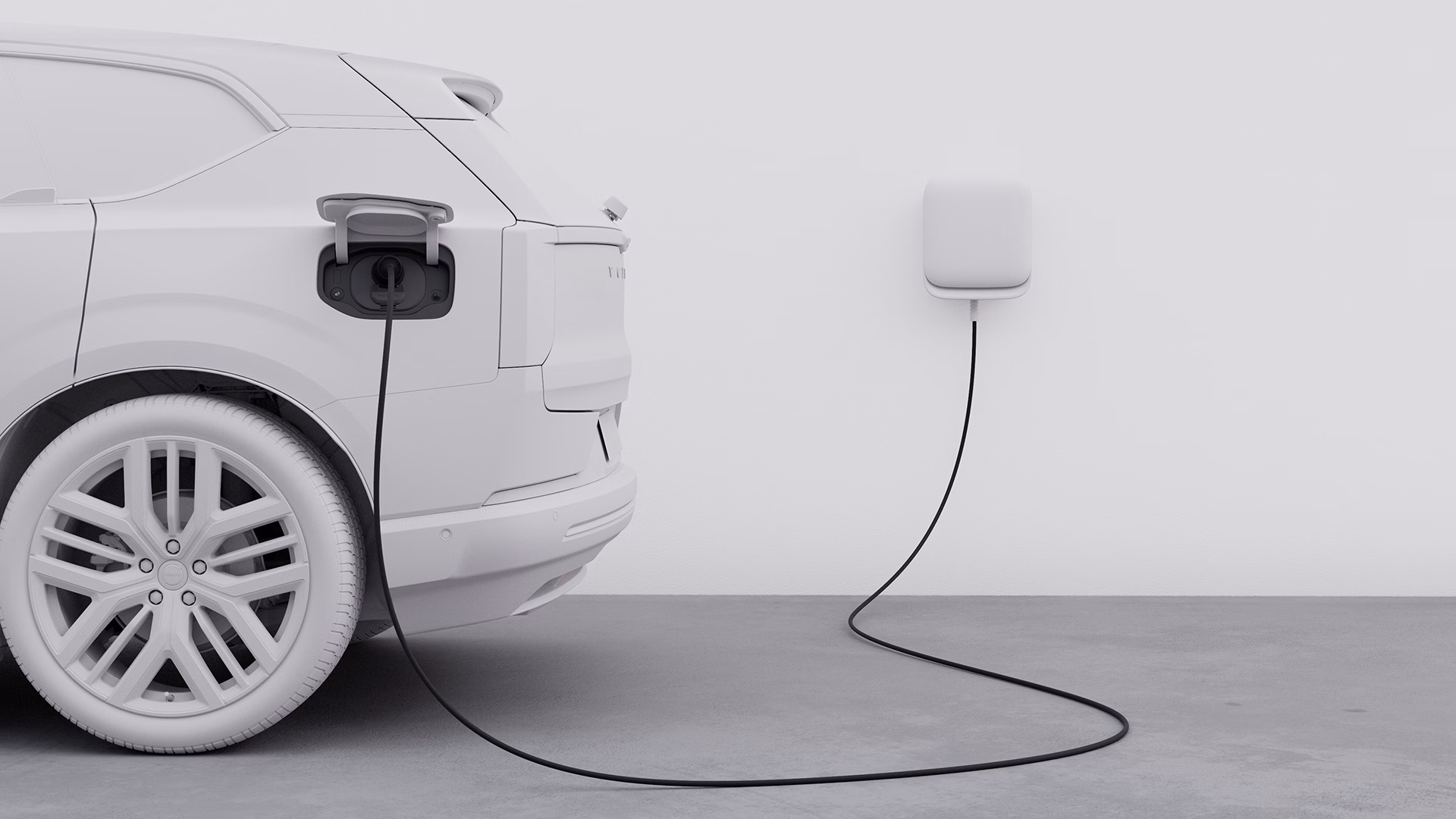 Внедорожник Volvo заряжается на настенной зарядной станции, подчеркивая электрические возможности автомобиля.