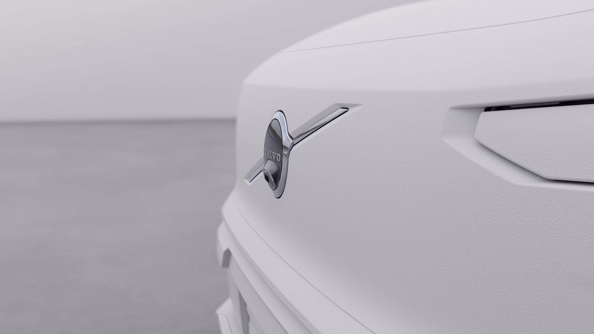 Крупный план логотипа Volvo на передней решетке радиатора, подчеркивающего эмблему бренда.