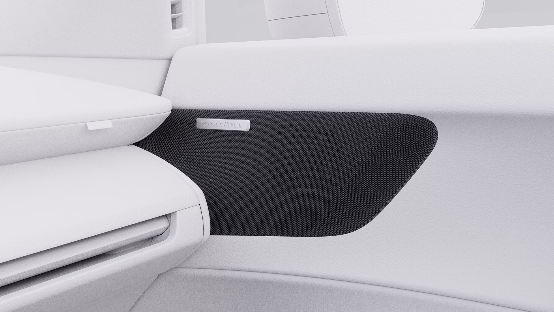 Динамик Bowers & Wilkins, встроенный в дверную панель белого автомобиля Volvo, крупным планом.