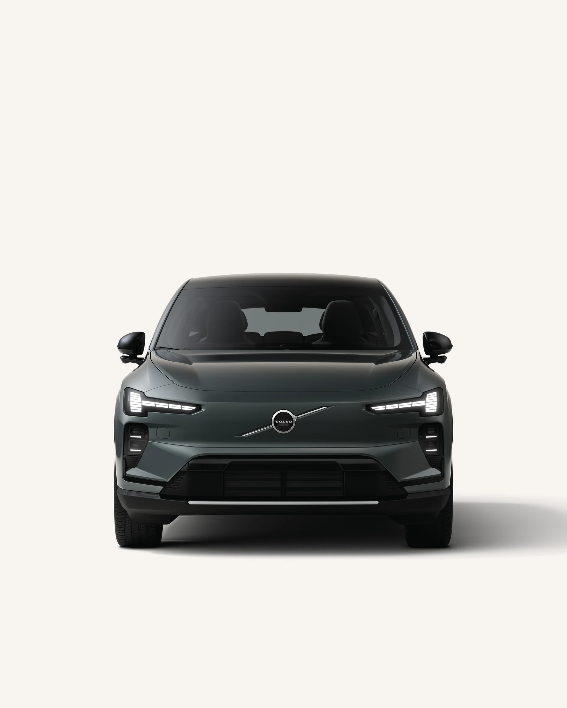 Вид спереди, демонстрирующий изысканную переднюю часть Volvo EX60 в белой студии.