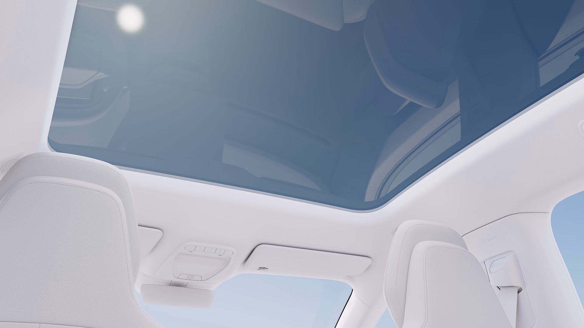 Вид салона автомобиля Volvo с большой панорамной стеклянной крышей и светлыми сиденьями.