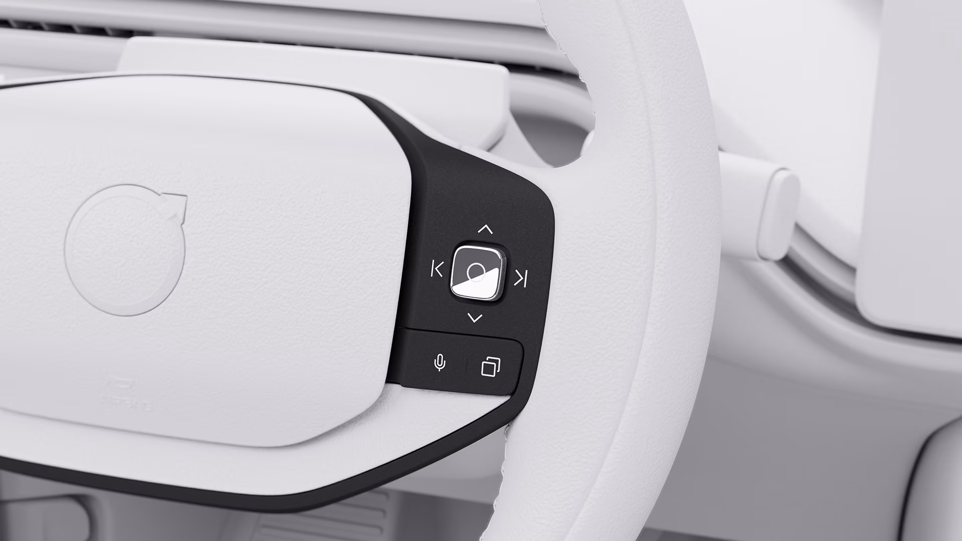 Крупный план рулевого колеса Volvo со встроенными кнопками управления, включая навигационные стрелки, микрофон и значки меню.