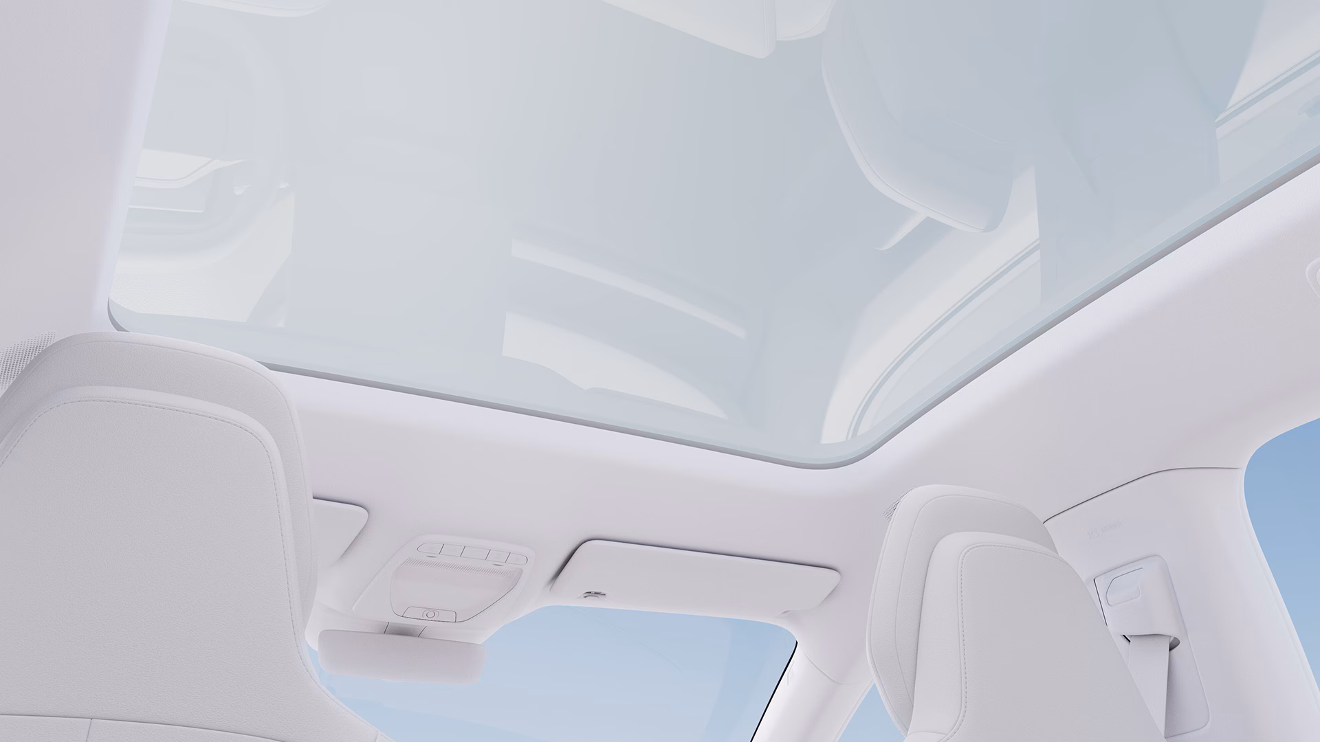 Вид салона автомобиля Volvo с большой панорамной стеклянной крышей и светлыми сиденьями.