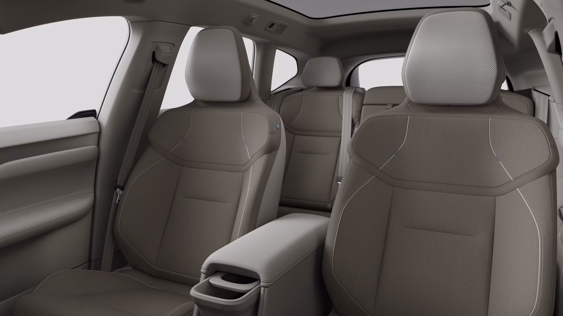 Салон автомобиля Volvo с задними пассажирскими сиденьями и центральной консолью на простом фоне студии.
