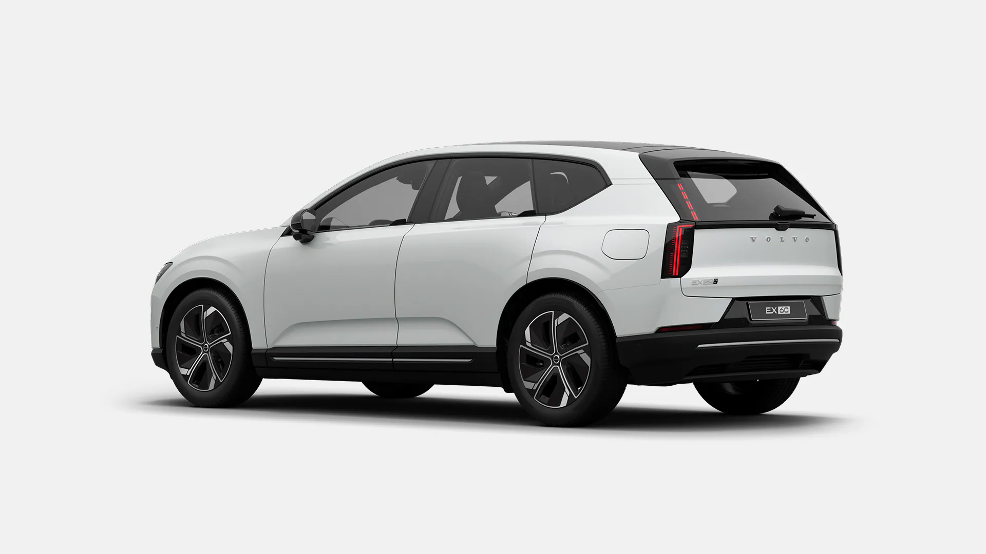 Вид сзади и сбоку на белый внедорожник Volvo EX60 с современным дизайном и характерными задними фонарями.