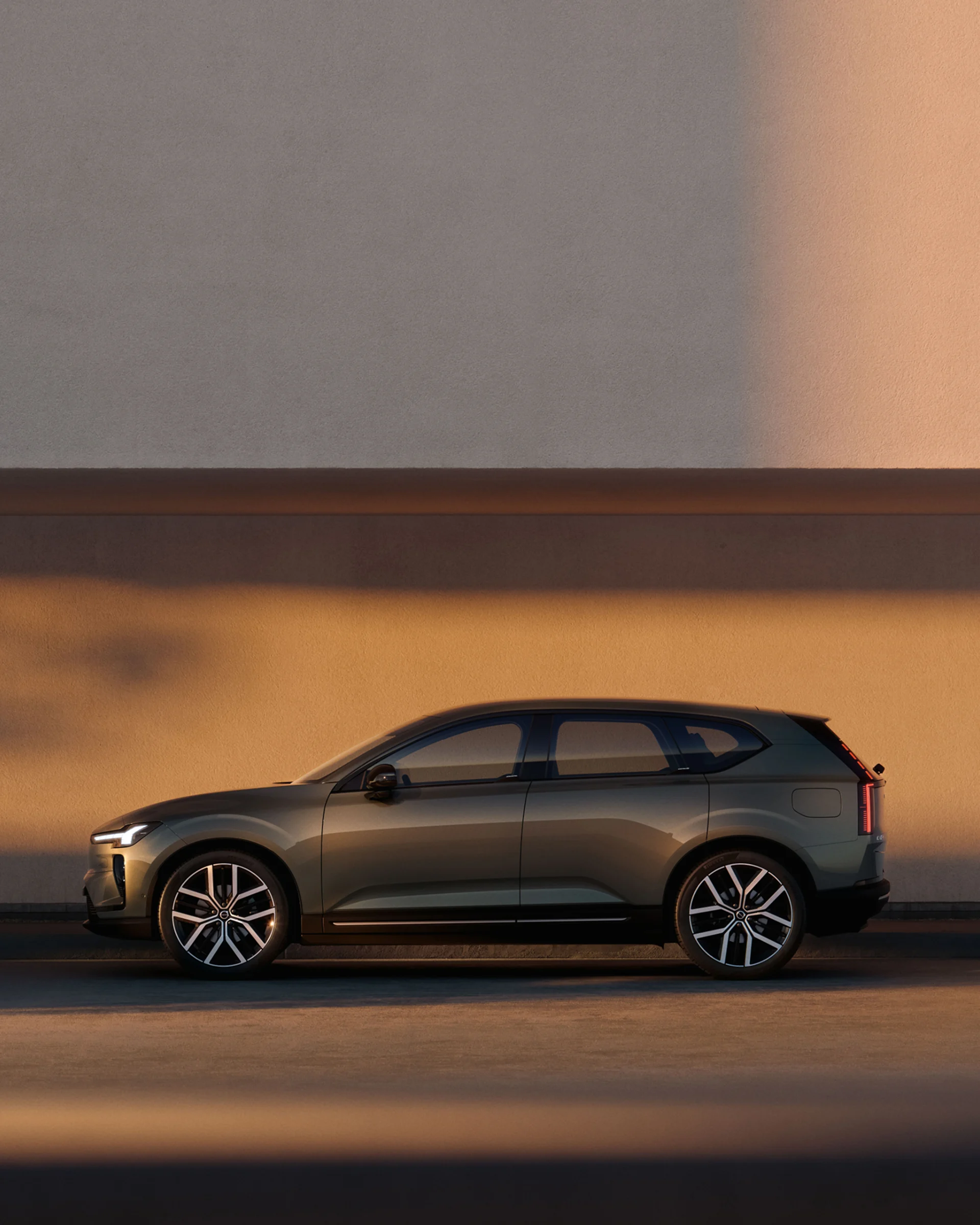 Volvo EX60 припаркован у стены, вид сбоку.