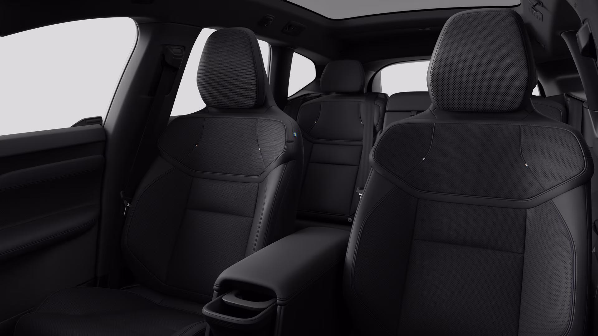 Салон автомобиля Volvo с задними пассажирскими сиденьями и центральной консолью на простом фоне студии.
