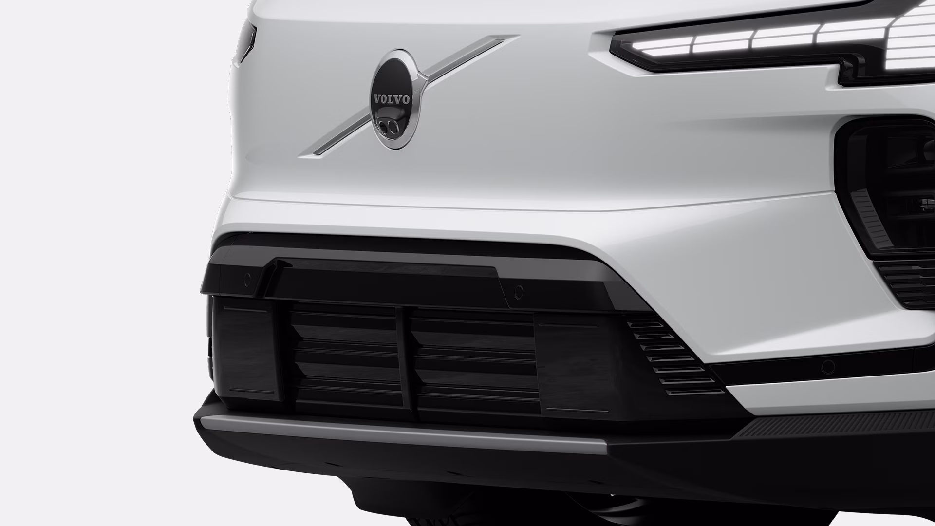 Крупный план задней части белого автомобиля Volvo с логотипом Volvo и современным дизайном задних фонарей.