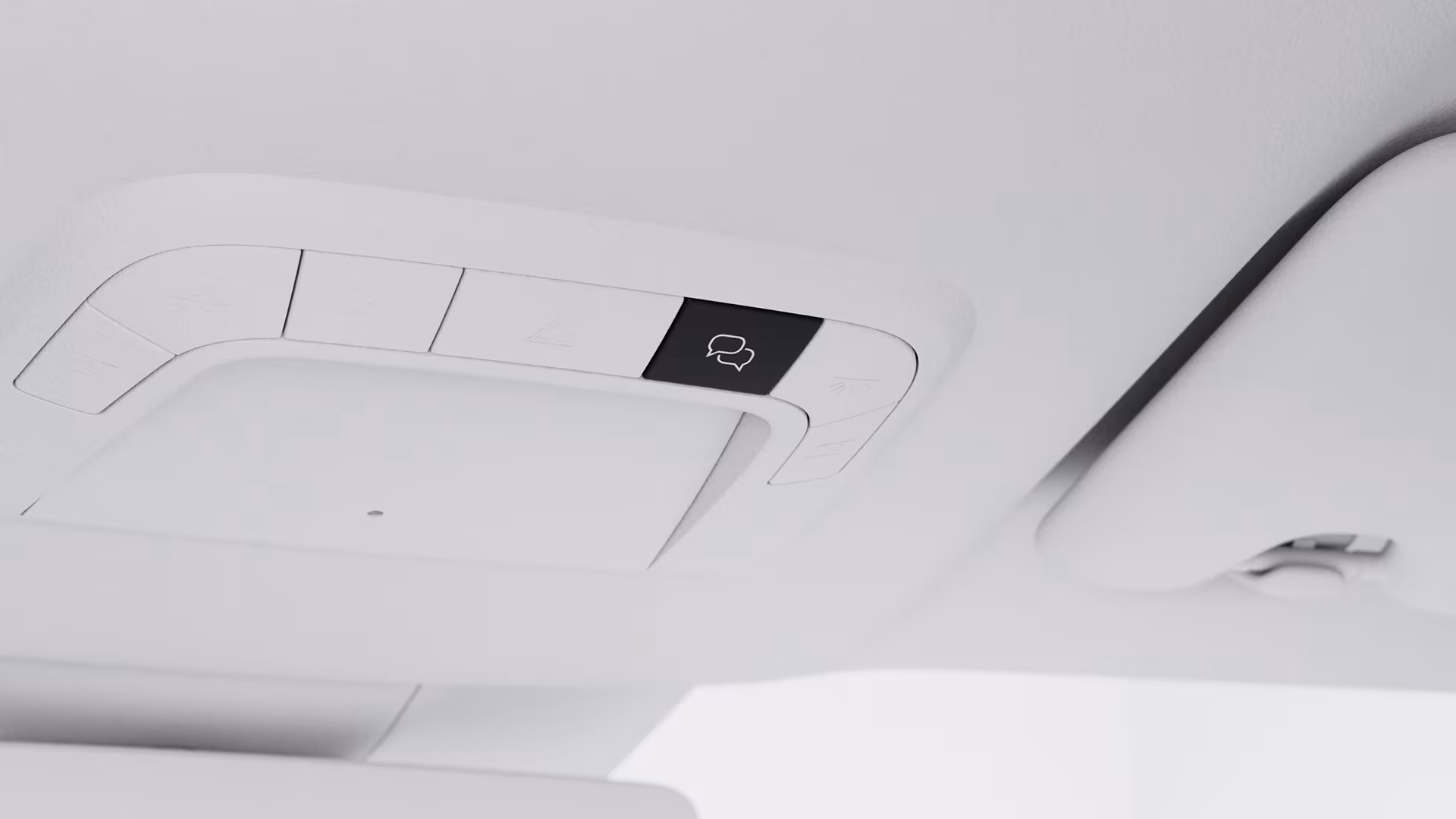 Крупный план потолочной консоли в автомобиле Volvo, на которой выделена кнопка со значком облачка для связи или помощи в автомобиле.