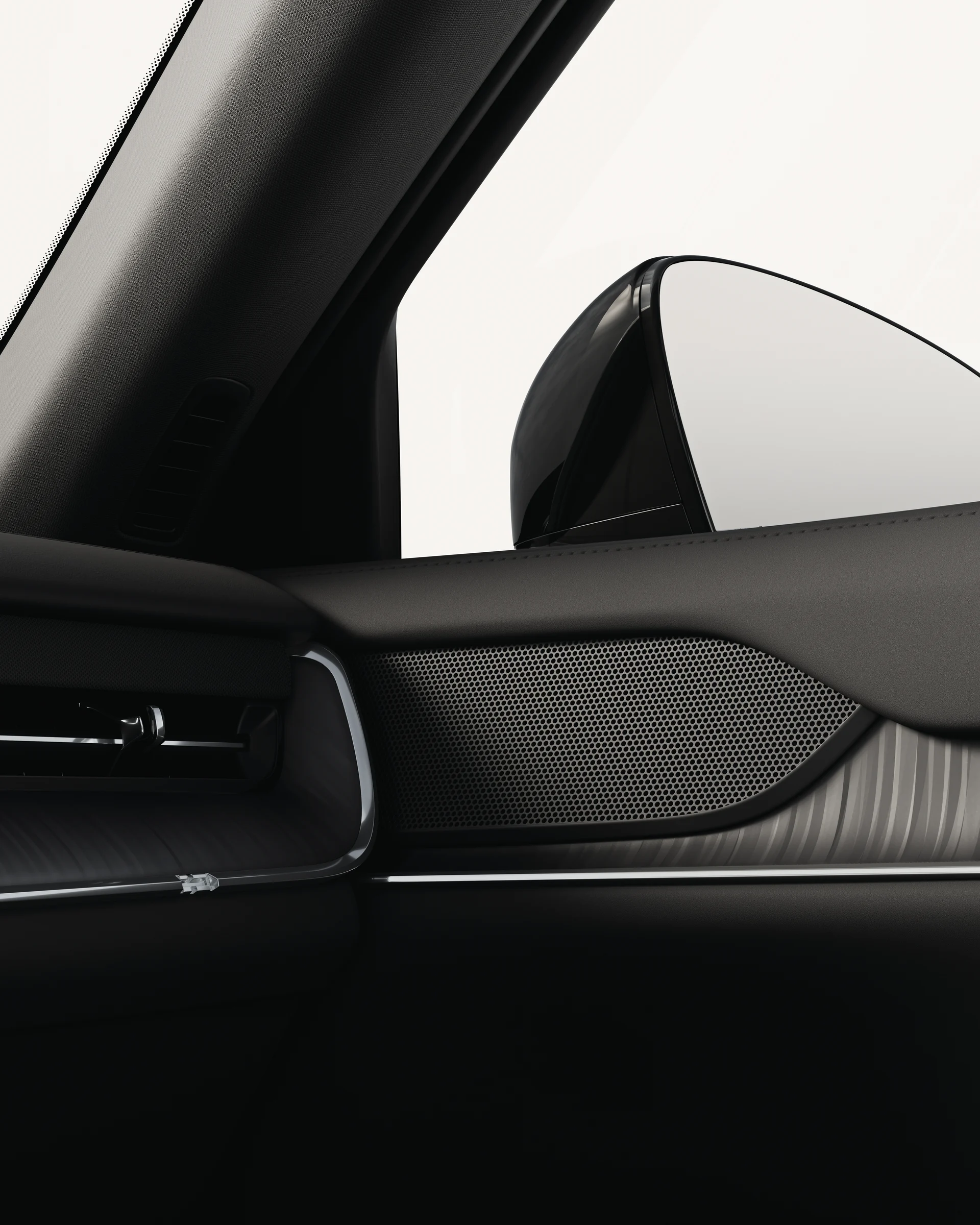 Крупный план стандартного динамика Volvo EX90 с матовой черной решеткой радиатора.
