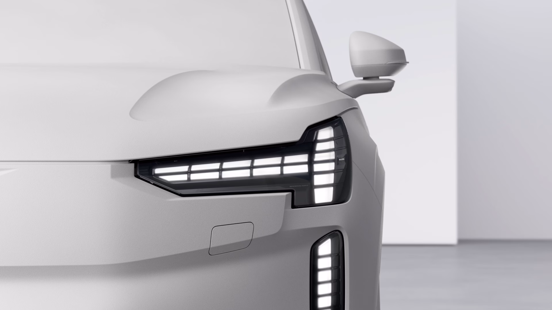 Крупный план передней левой фары и бокового зеркала автомобиля Volvo, подчеркивающий современный дизайн светодиодного освещения.