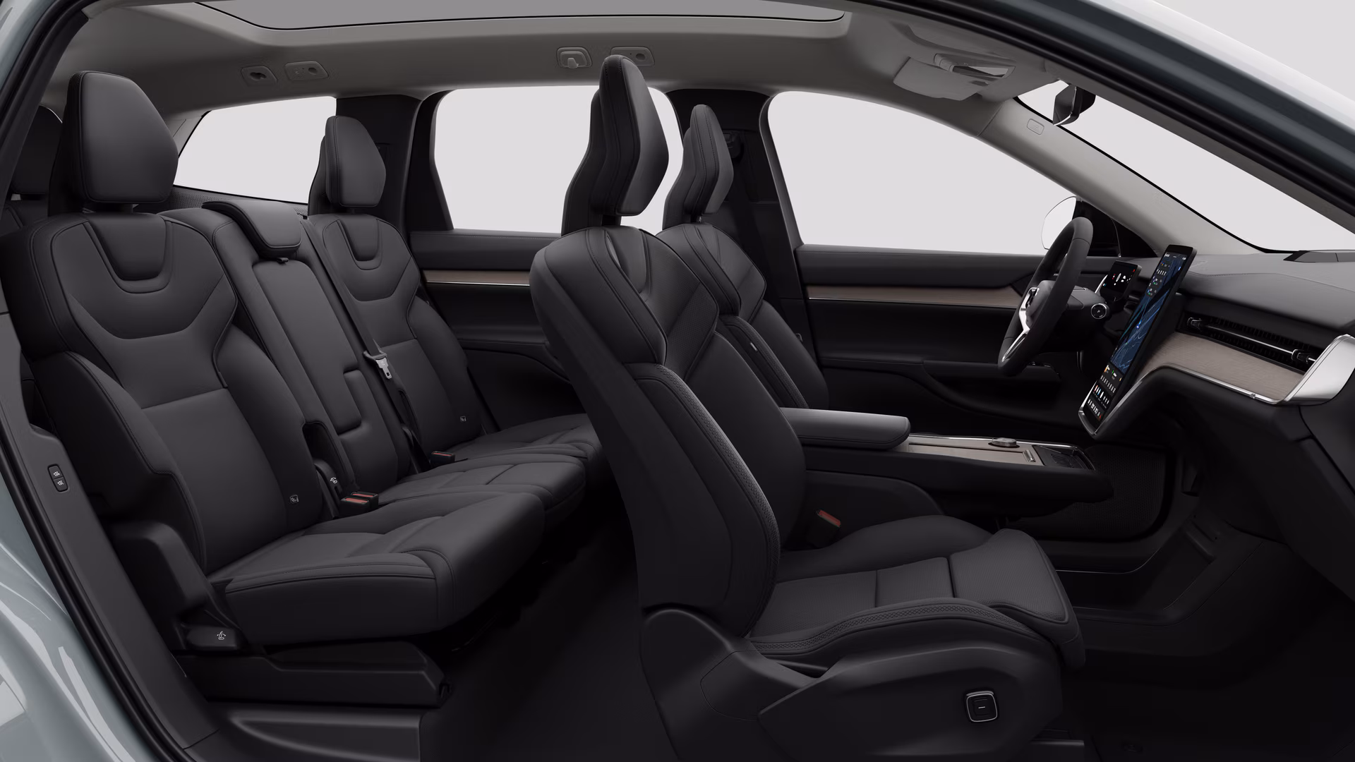 Салон автомобиля Volvo: передние сиденья, задние пассажирские сиденья, руль, приборная панель и центральная консоль на фоне студии.