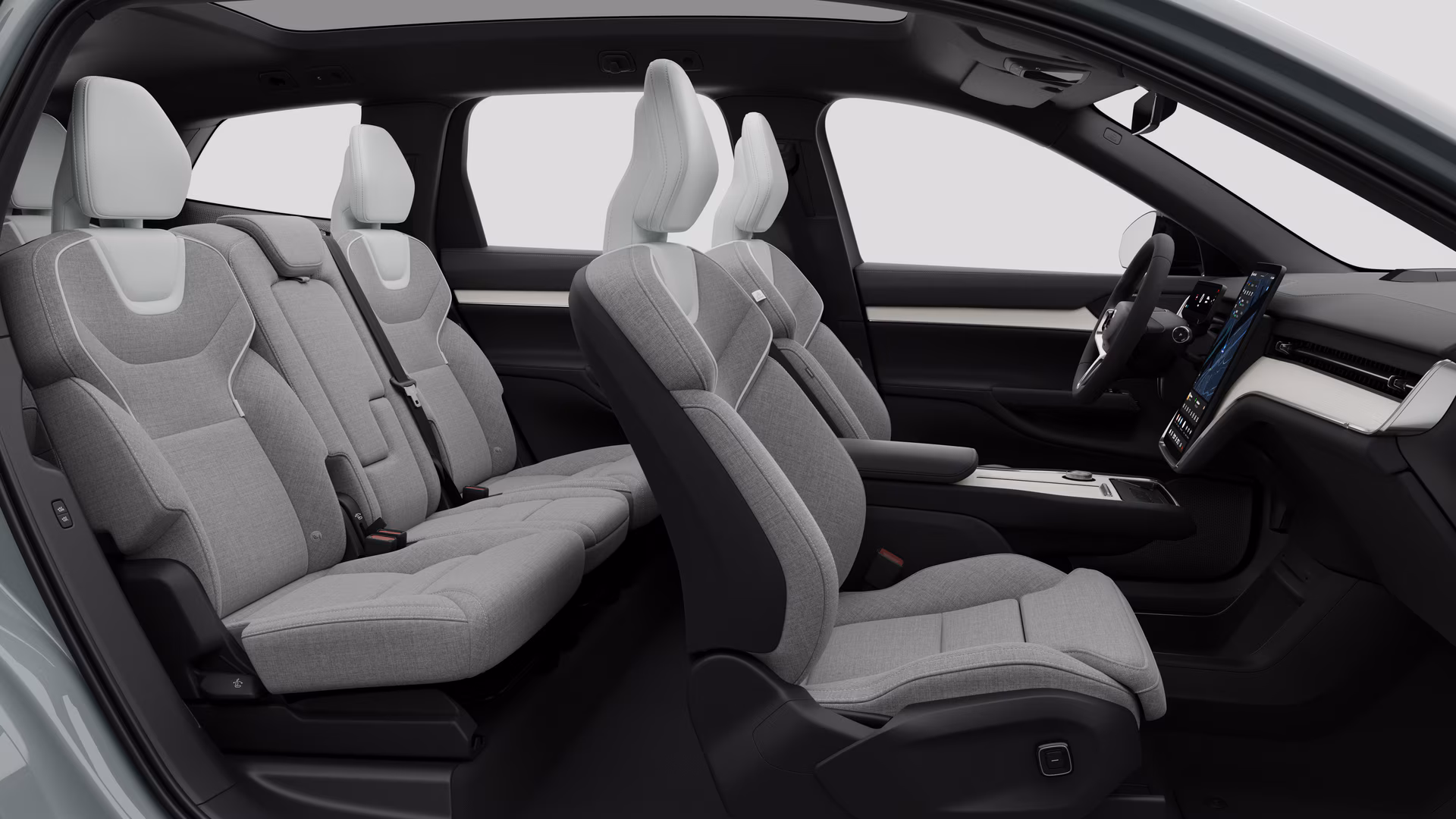 Салон автомобиля Volvo: передние сиденья, задние пассажирские сиденья, руль, приборная панель и центральная консоль на фоне студии.