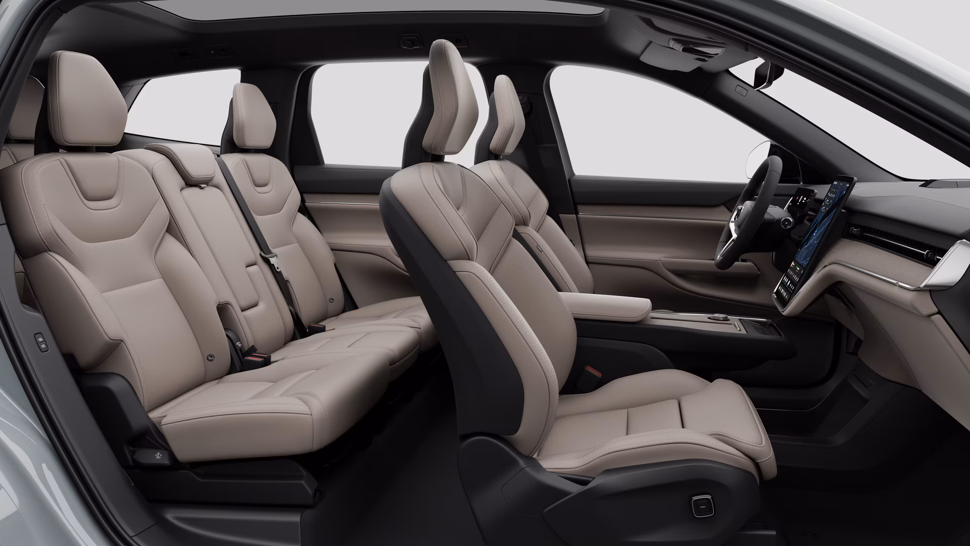 Салон автомобиля Volvo: передние сиденья, задние пассажирские сиденья, руль, приборная панель и центральная консоль на фоне студии.