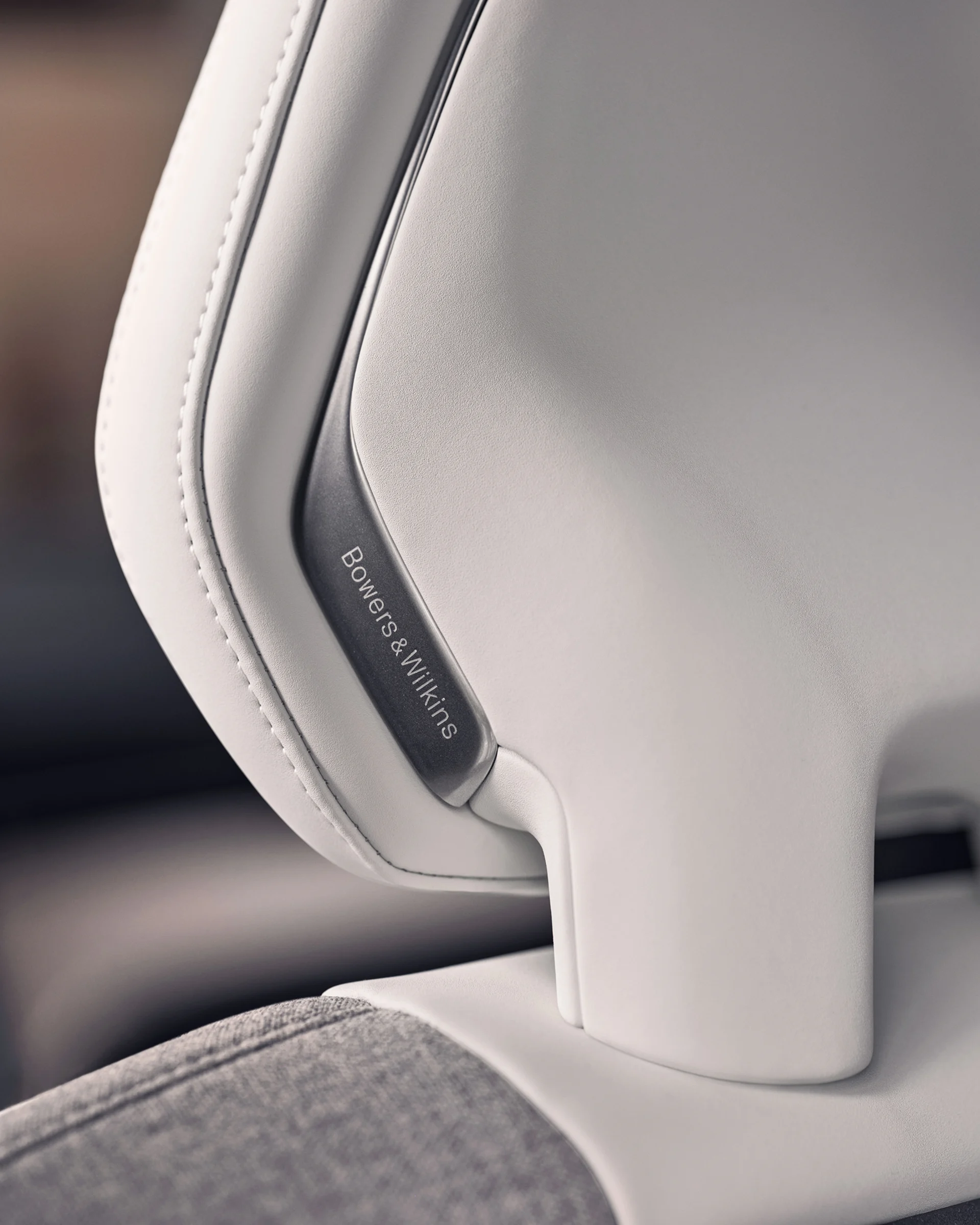 Крупный план деталей сидений Volvo EX90 с первоклассной строчкой и этикеткой Bowers & Wilkins.