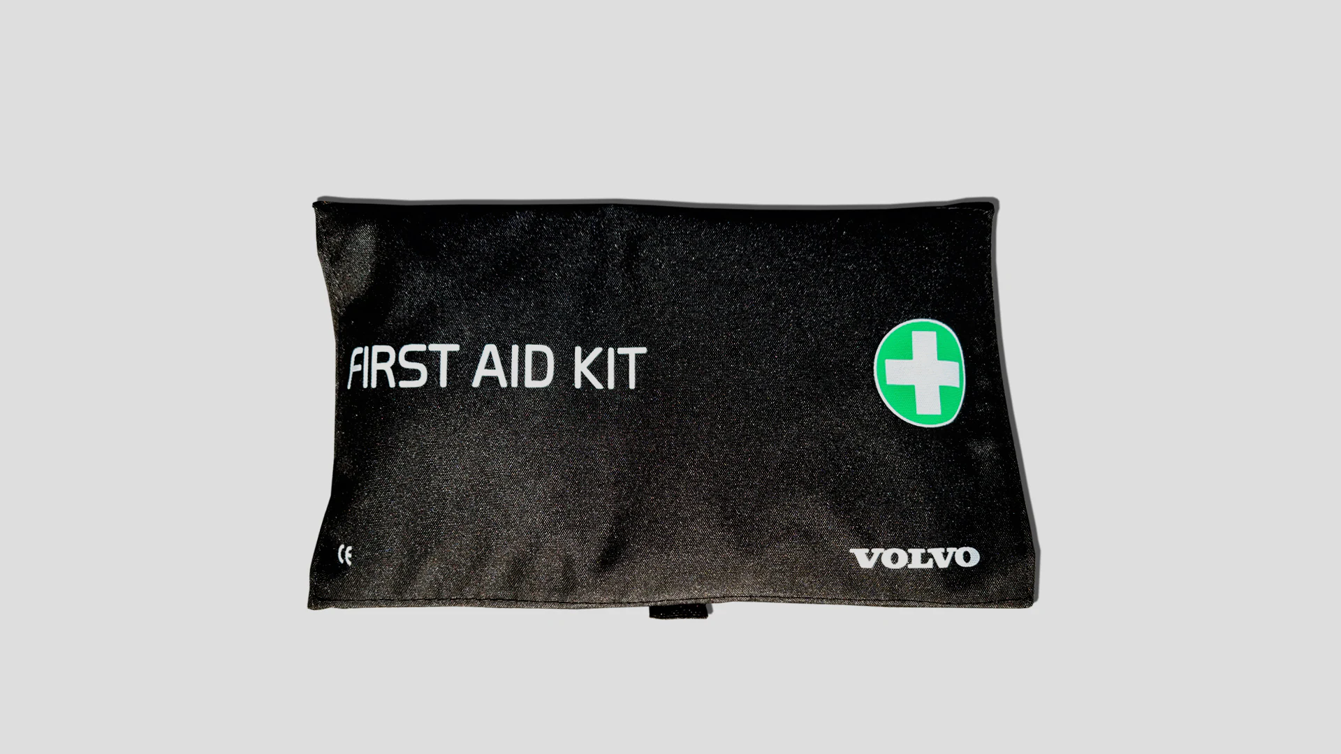 Подсумок аптечки марки Volvo с зеленым крестиком и надписью «FIRST AID KIT» спереди.