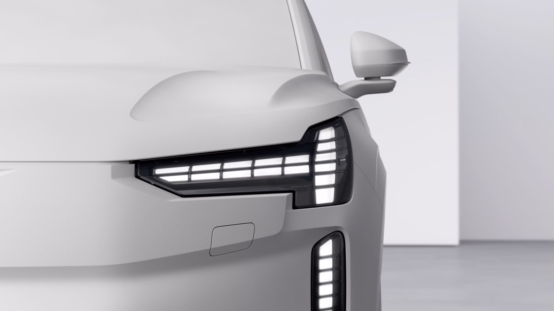 Крупный план передней левой фары и бокового зеркала автомобиля Volvo, подчеркивающий современный дизайн светодиодного освещения.