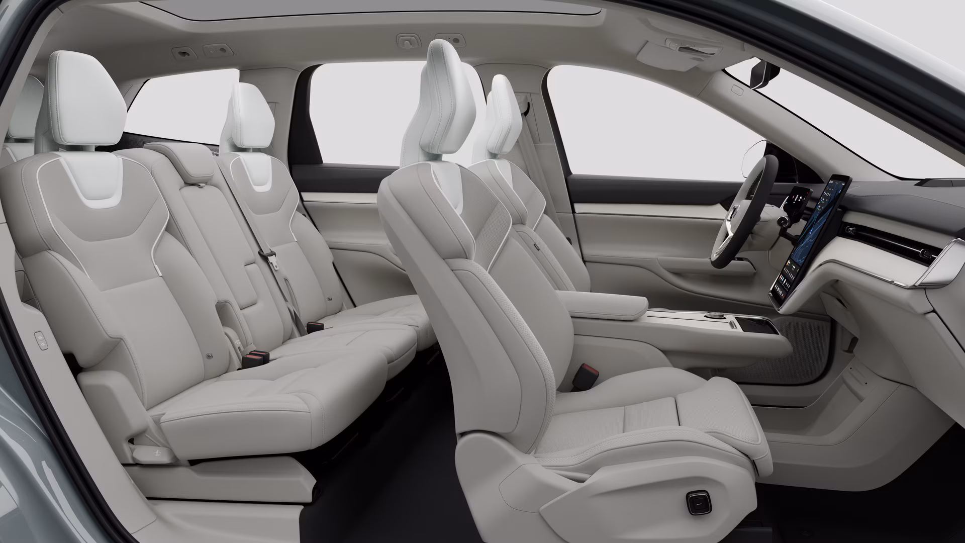 Салон автомобиля Volvo: передние сиденья, задние пассажирские сиденья, руль, приборная панель и центральная консоль на фоне студии.