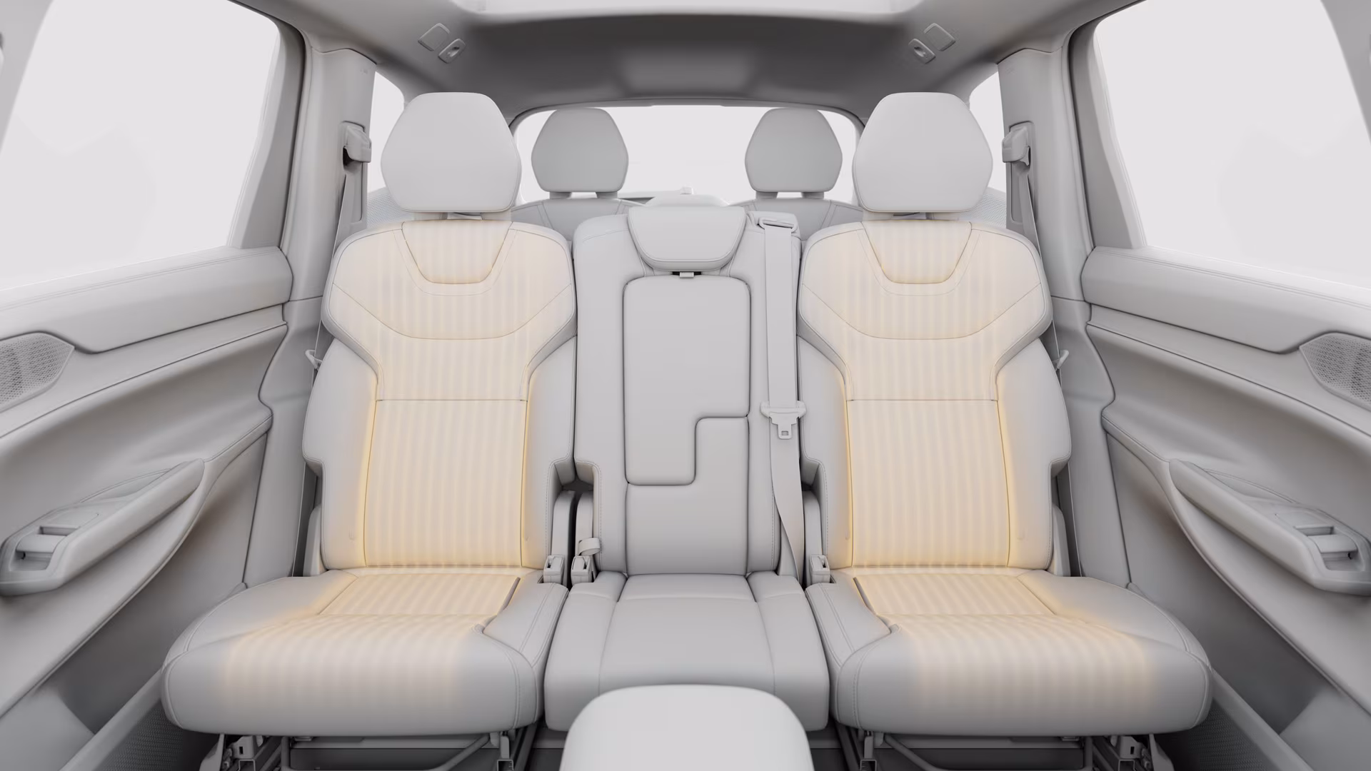 Вид изнутри автомобиля Volvo, со вторым и третьим рядами сидений со светлой обивкой, подчеркивающими просторные сиденья и подголовники.