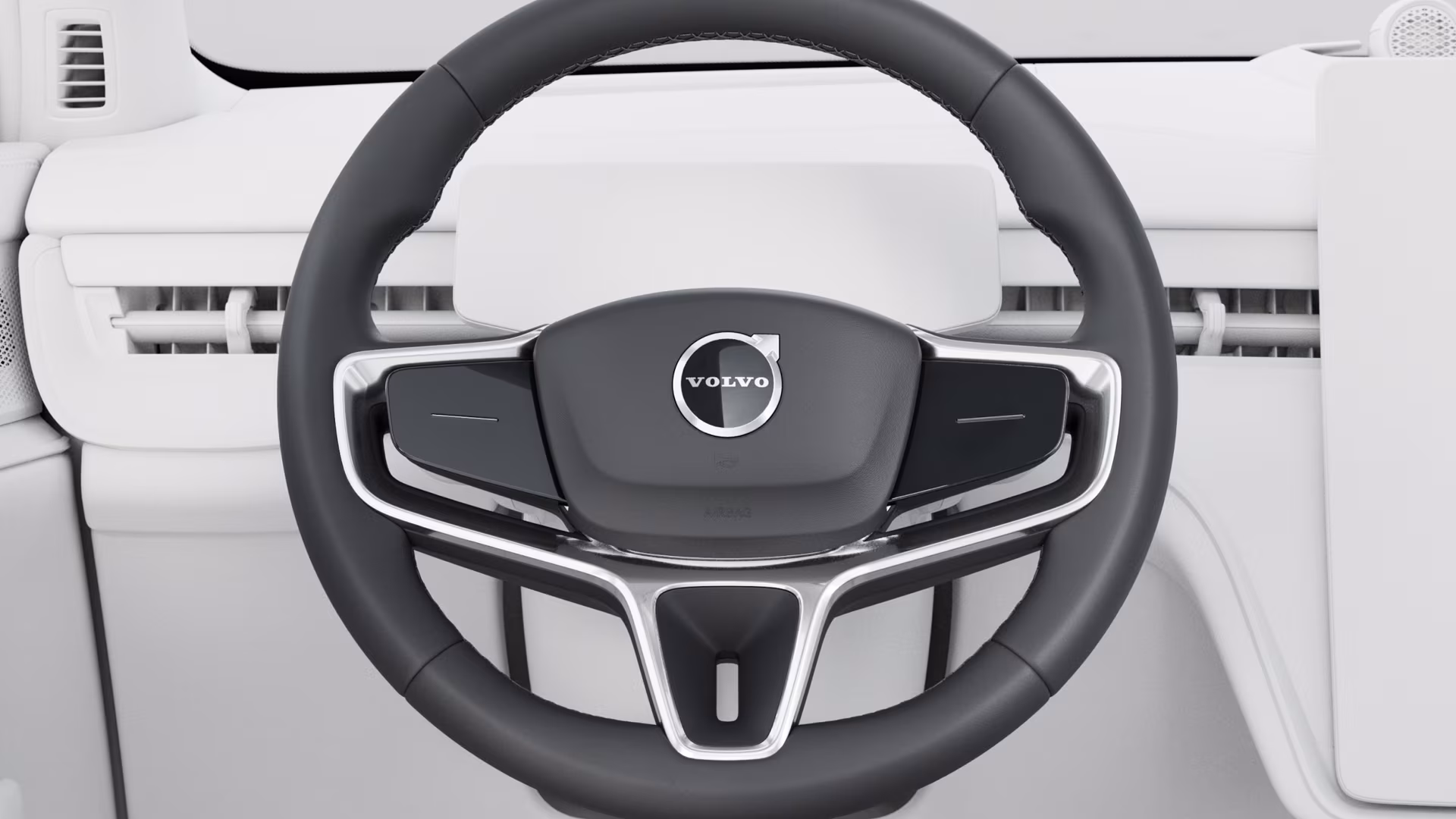 Крупный план рулевого колеса Volvo со встроенными органами управления на фоне современной светлой приборной панели.