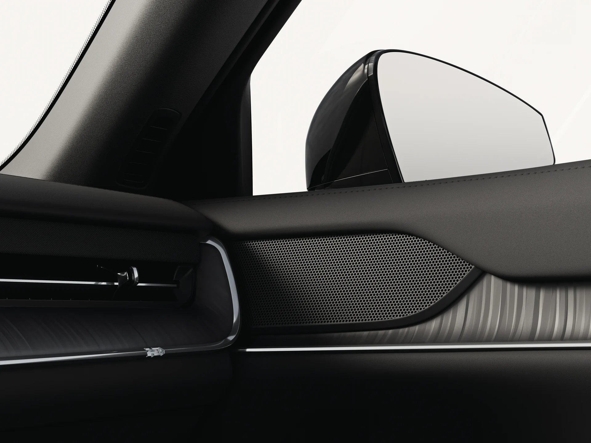 Крупный план стандартного динамика Volvo EX90 с матовой черной решеткой радиатора.