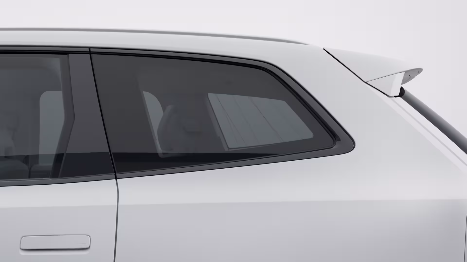 Крупный план заднего бокового окна и двери белого автомобиля Volvo, подчеркивающий дизайн окон и задний спойлер.