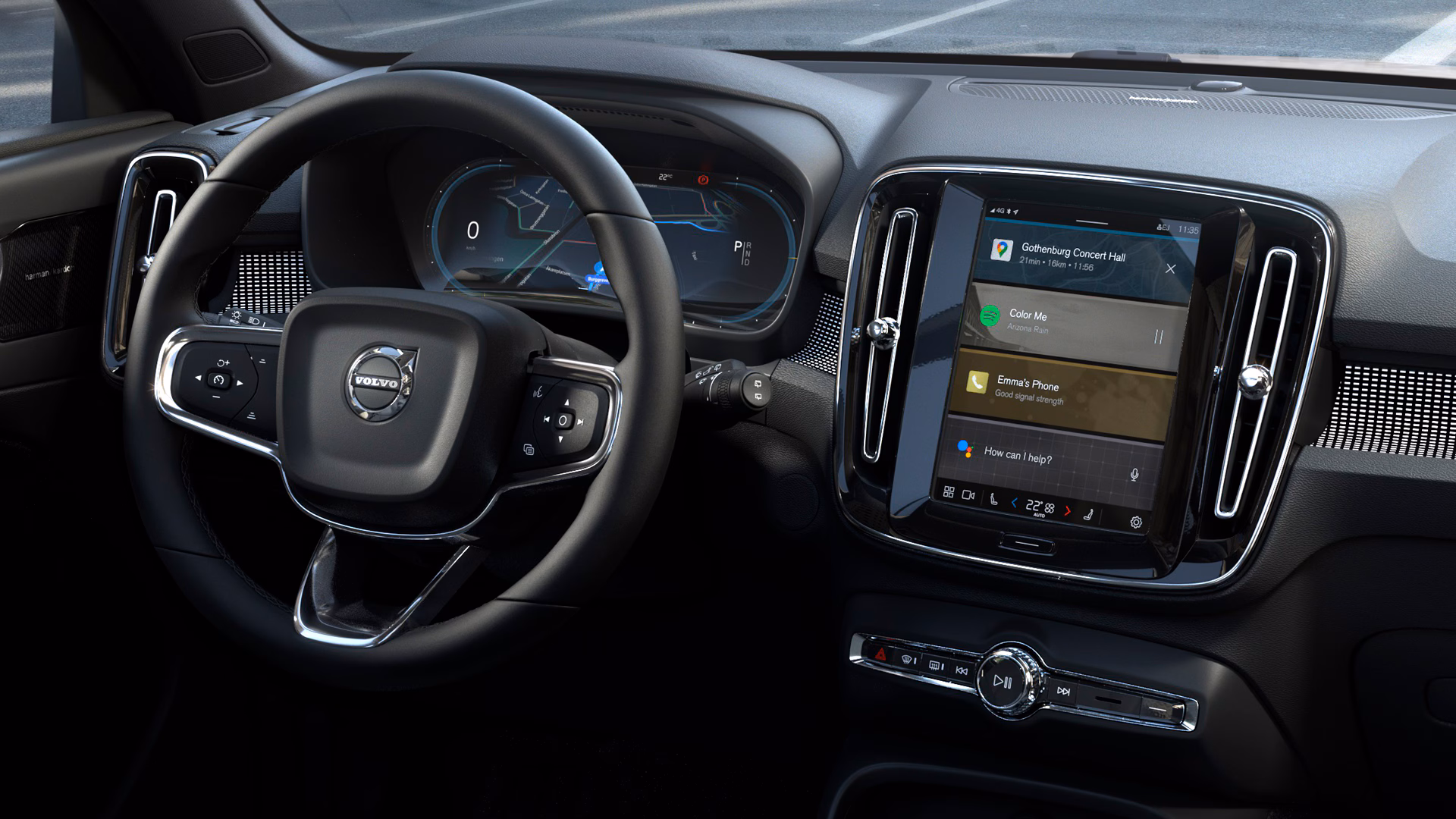 Вид изнутри автомобиля Volvo с цифровым дисплеем водителя и центральным сенсорным экраном с функциями навигации, музыки и телефона.