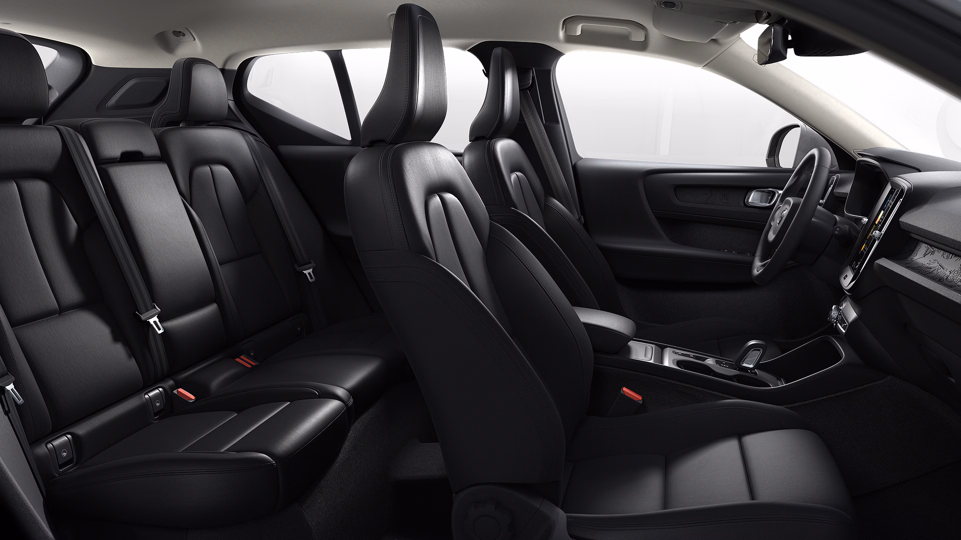 Вид салона автомобиля Volvo с черными кожаными сиденьями и современным дизайном приборной панели.
