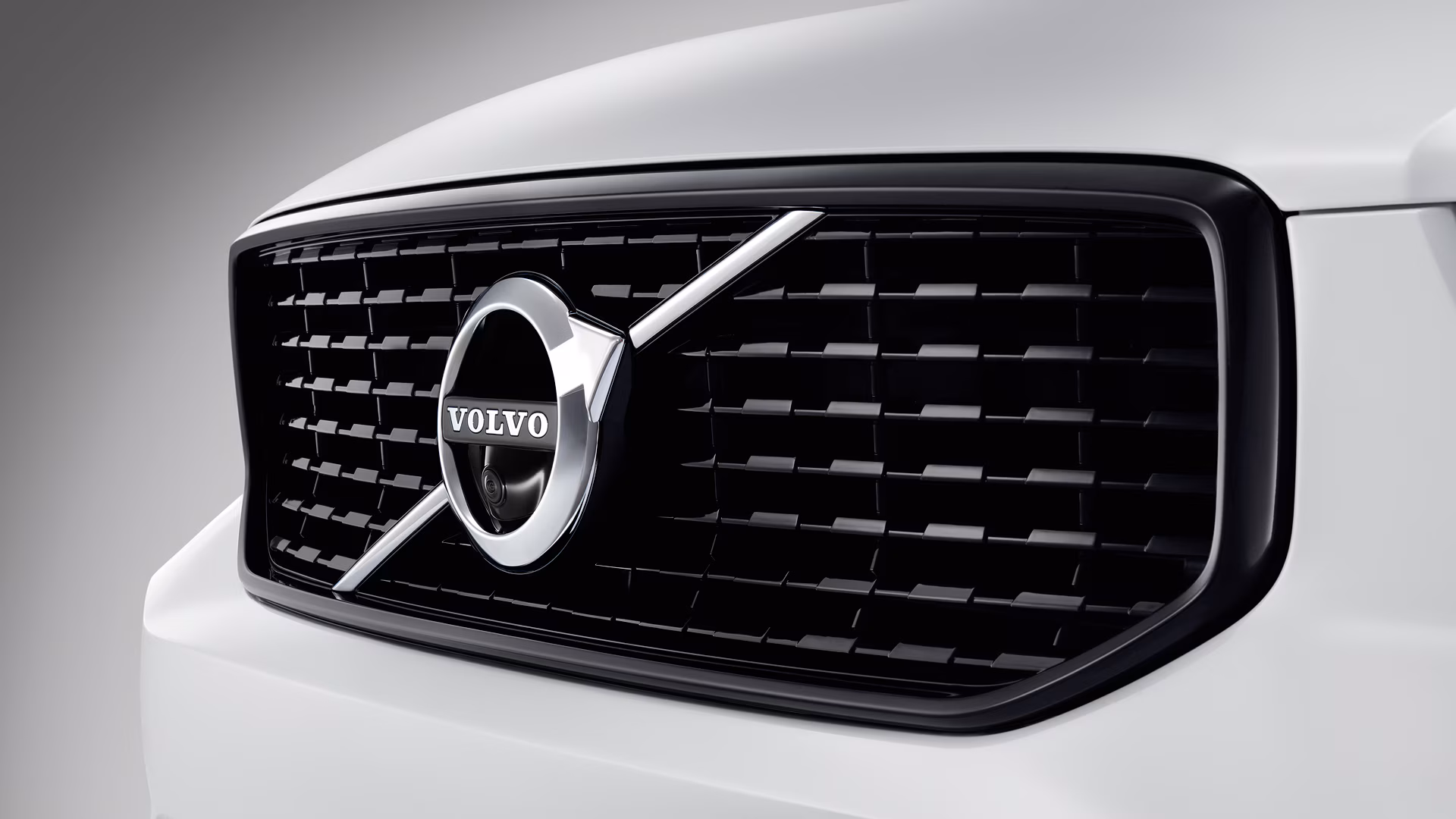 Крупный план решетки радиатора Volvo с логотипом Volvo в центре.