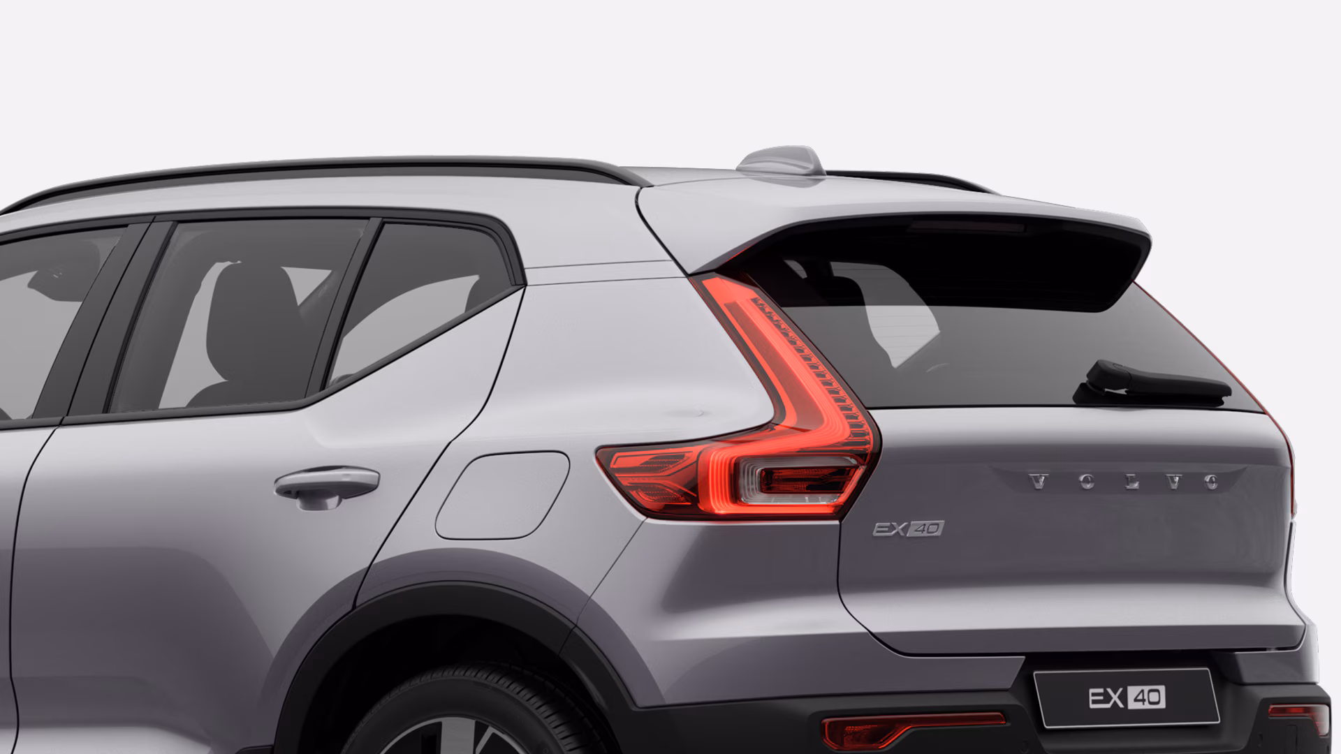 Вид сзади и сбоку на Volvo EX40, подчеркивающий характерный дизайн и фирменный стиль задних фонарей.