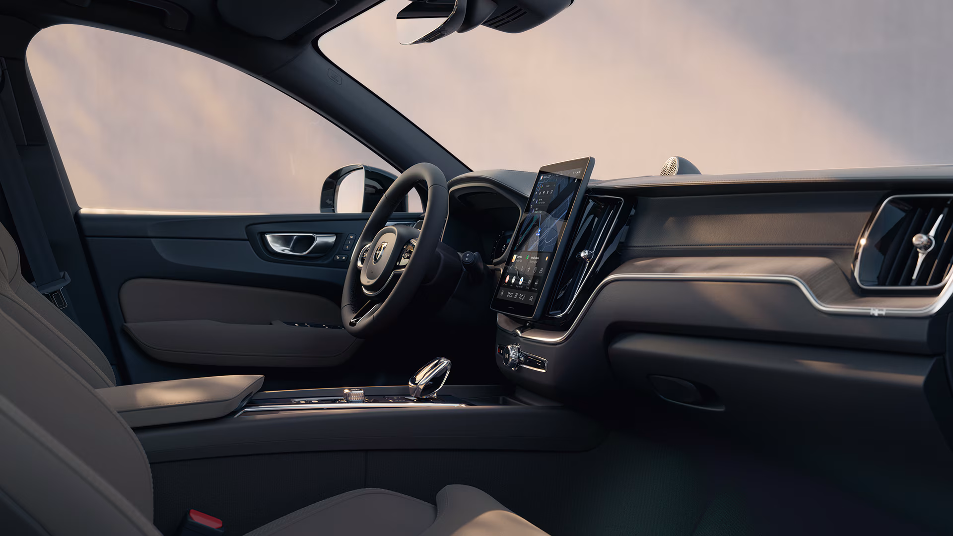 Вид салона автомобиля Volvo с современной приборной панелью, большим центральным сенсорным дисплеем и материалами премиум-класса.