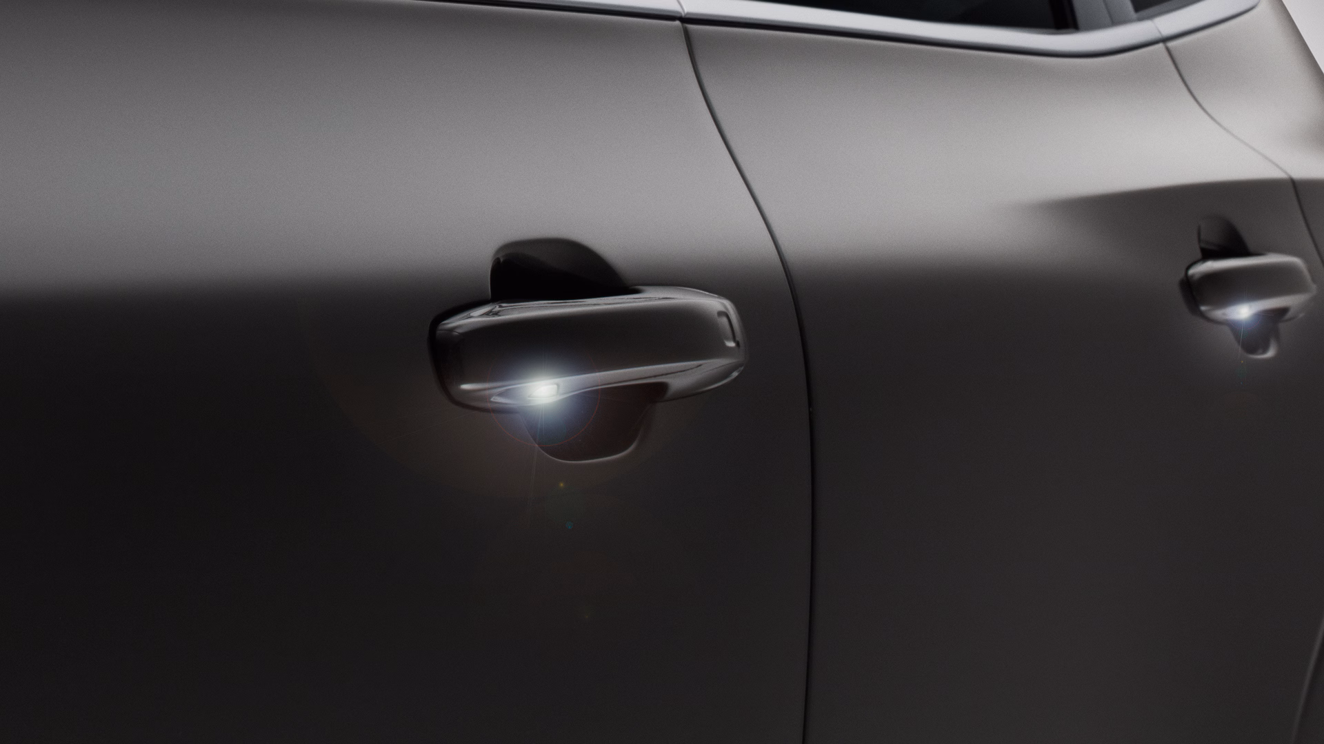 Крупный план дверных ручек Volvo с подсветкой, подчеркивающих безопасность или удобство.