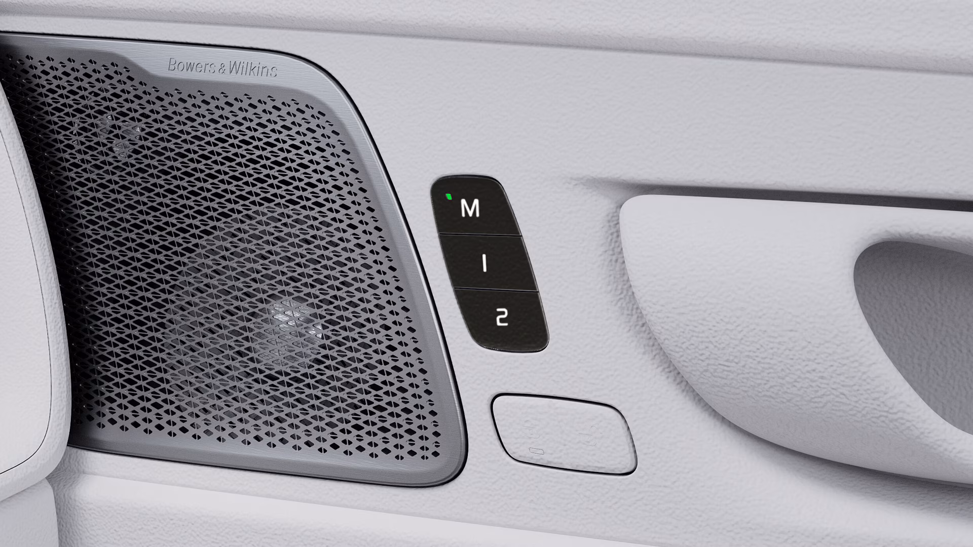 Крупный план дверной панели автомобиля Volvo, на которой видна решетка динамика Bowers & Wilkins и кнопки с надписями M, 1 и 2.