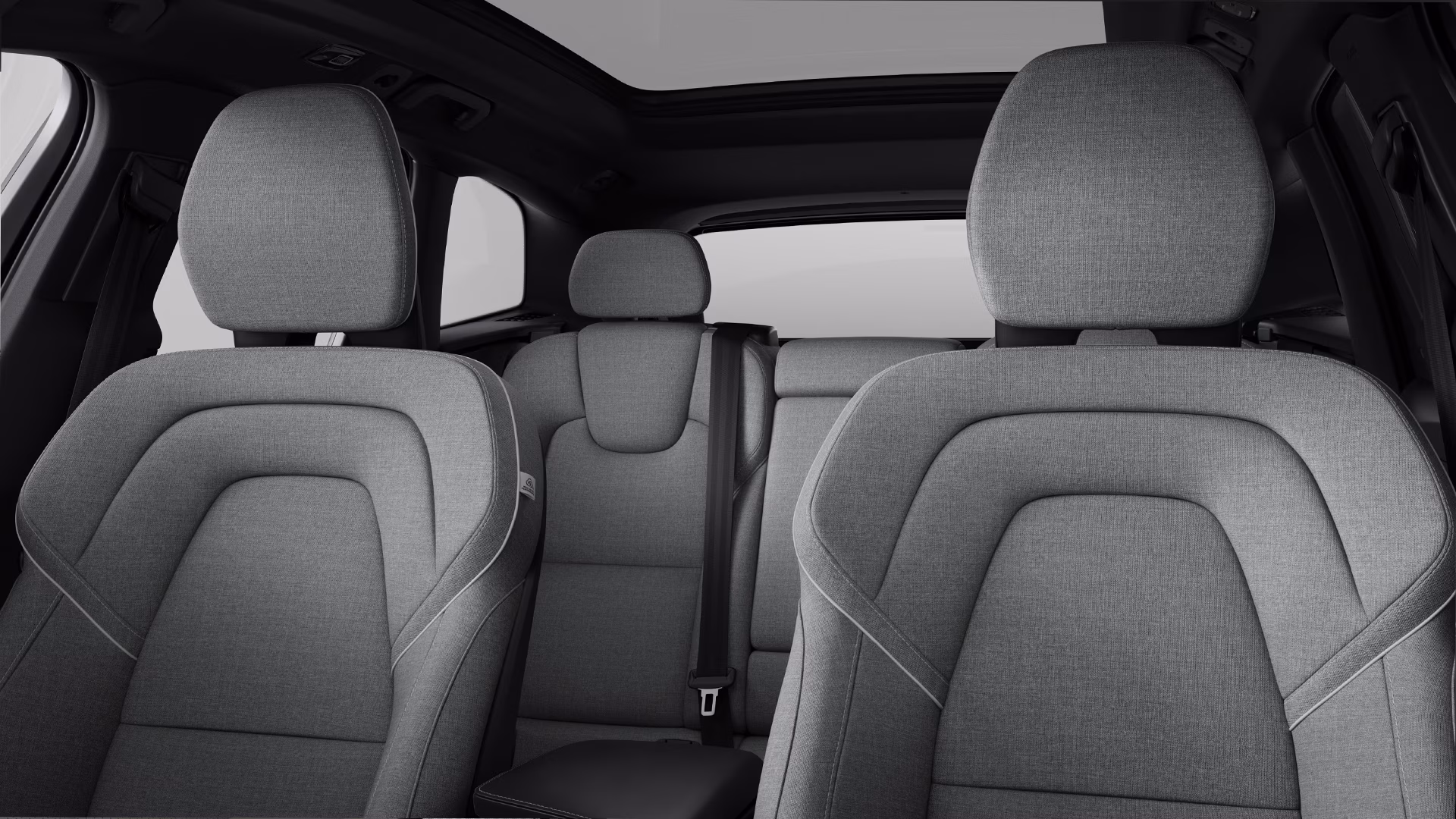 Вид салона автомобиля Volvo: передние и задние сиденья с серой обивкой и панорамным люком на крыше.