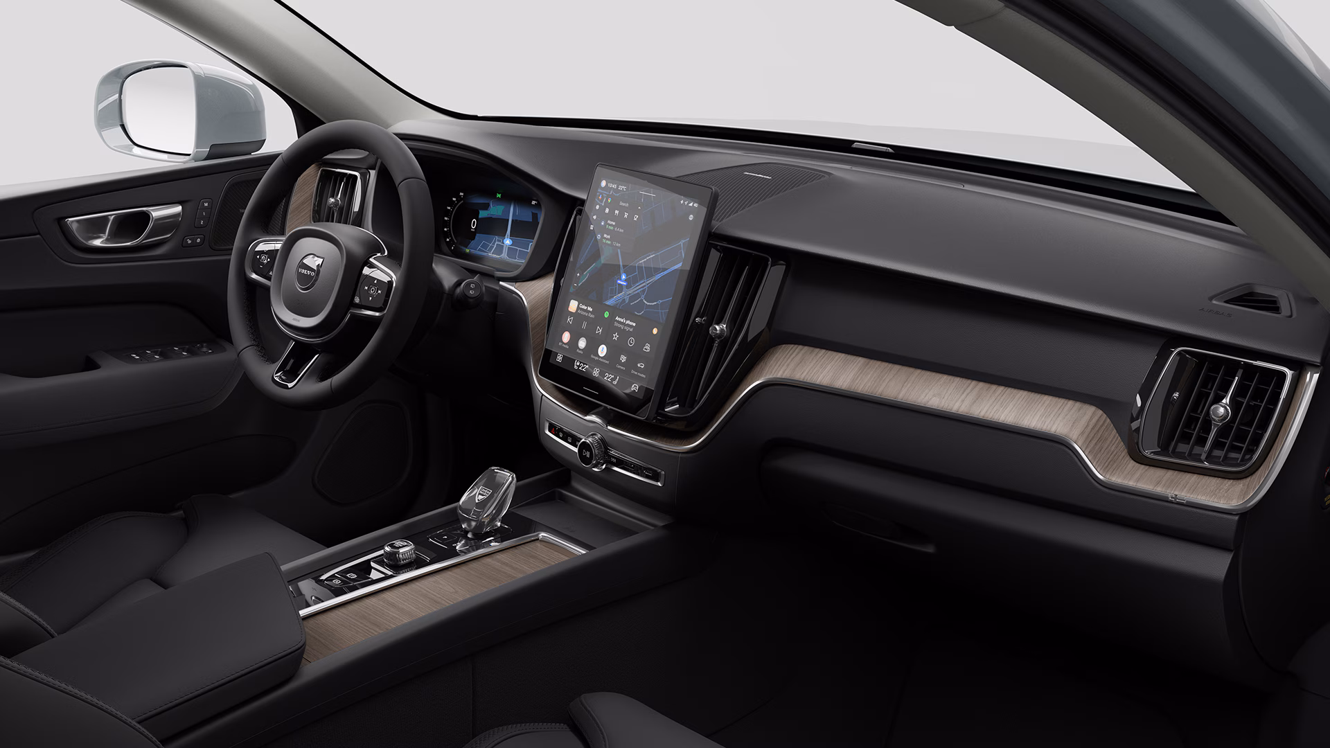 Вид салона автомобиля Volvo с современной приборной панелью с большим сенсорным дисплеем, цифровой комбинацией приборов и элементами из дерева.