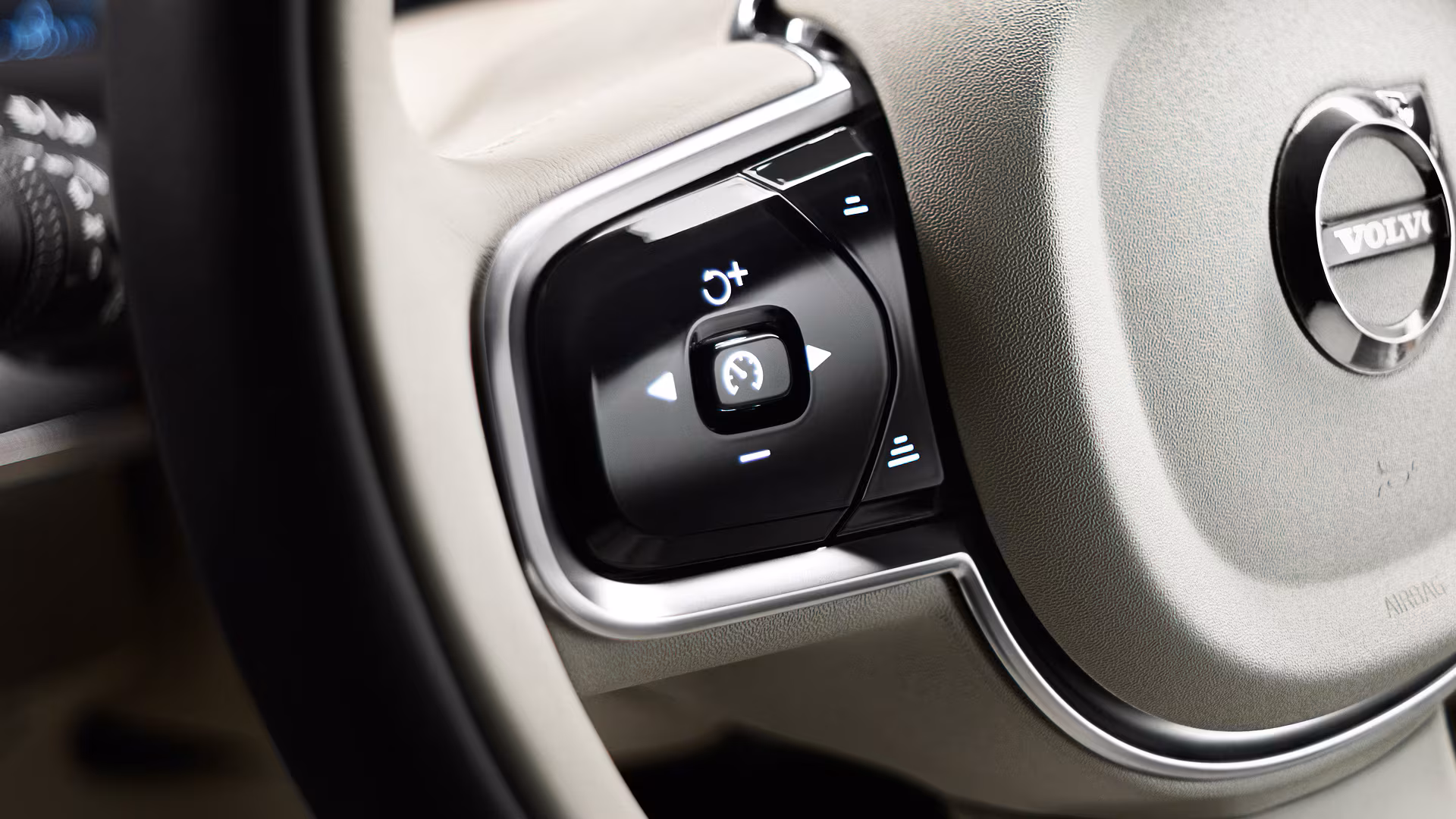 Крупный план круиз-контроля и органов управления на руле автомобиля Volvo.