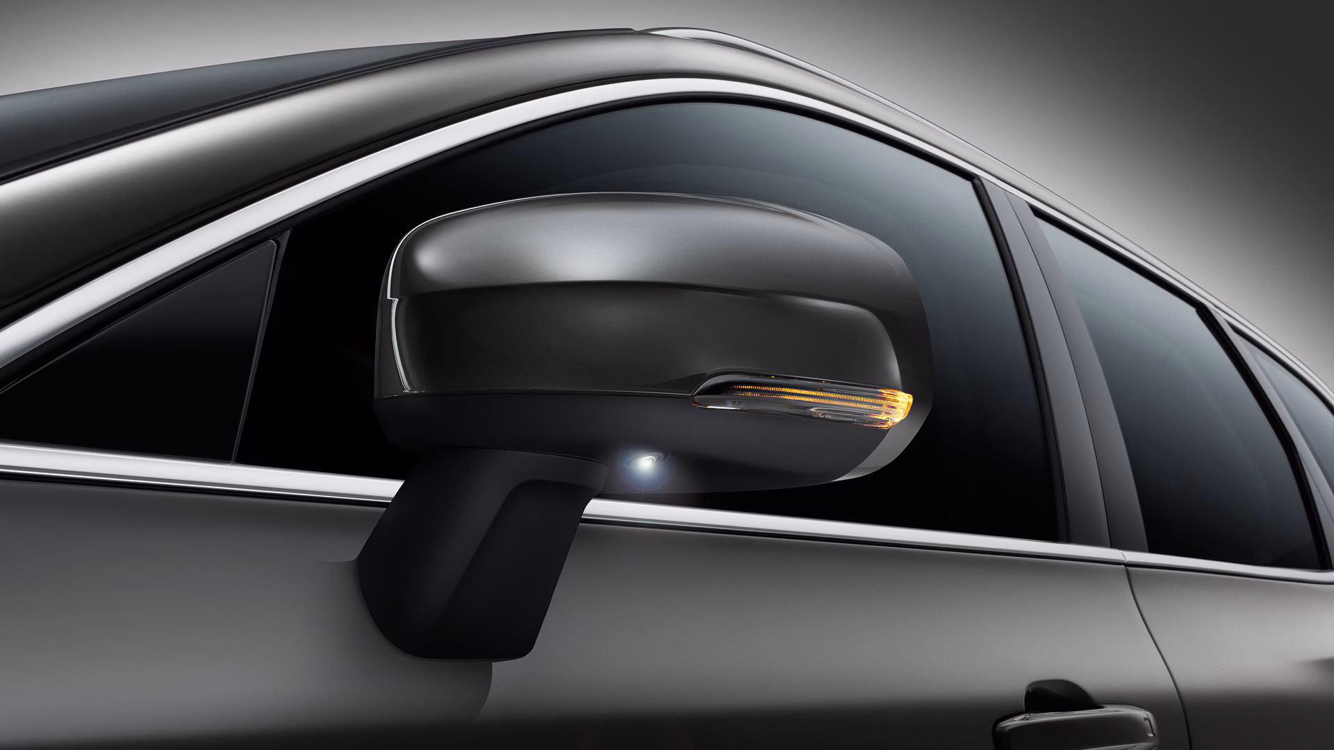 Боковое зеркало Volvo крупным планом со встроенным указателем поворота и камерой.