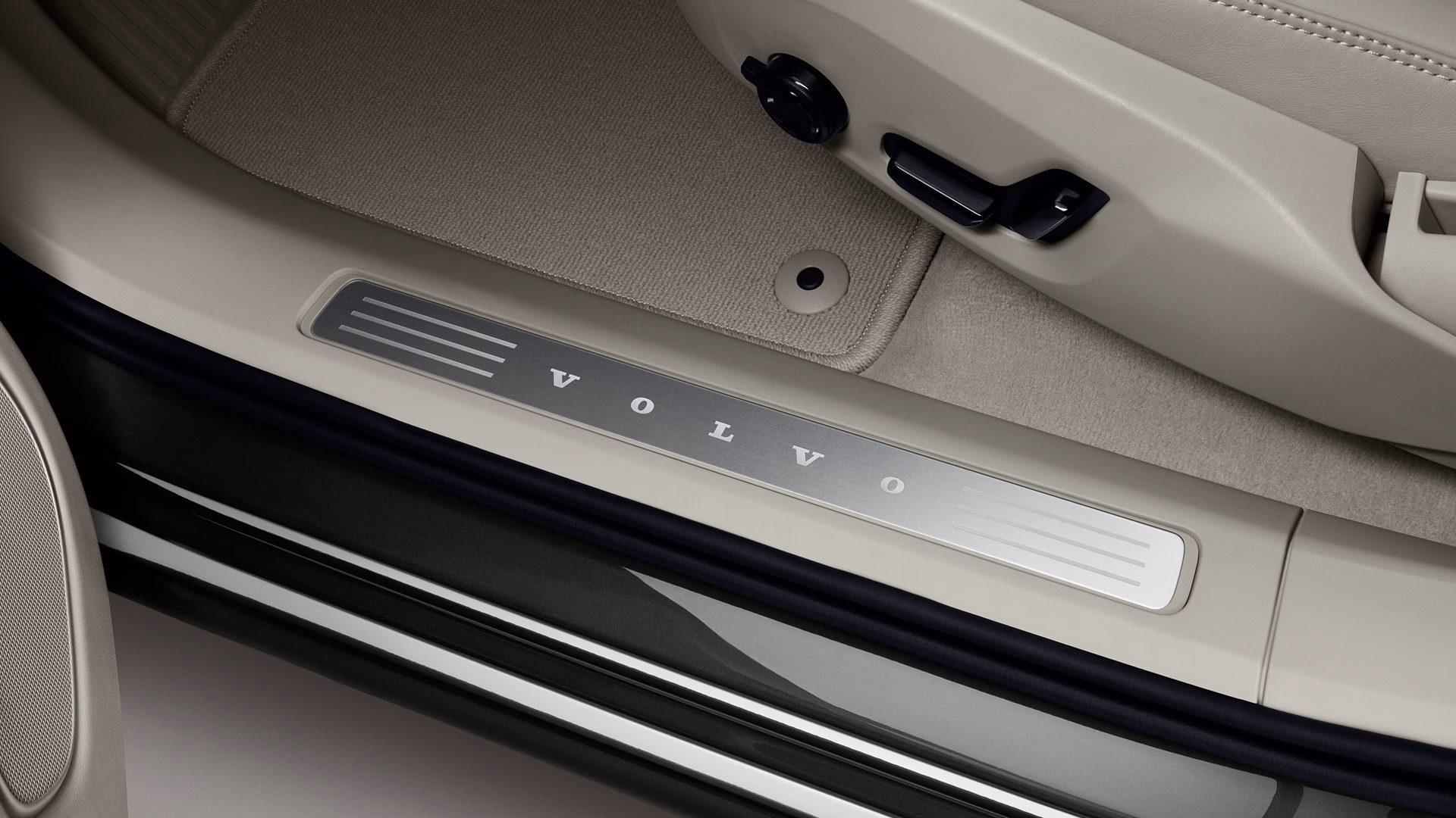 Крупный план порога внутренней двери автомобиля Volvo с надписью «VOLVO» на металлической пластине.