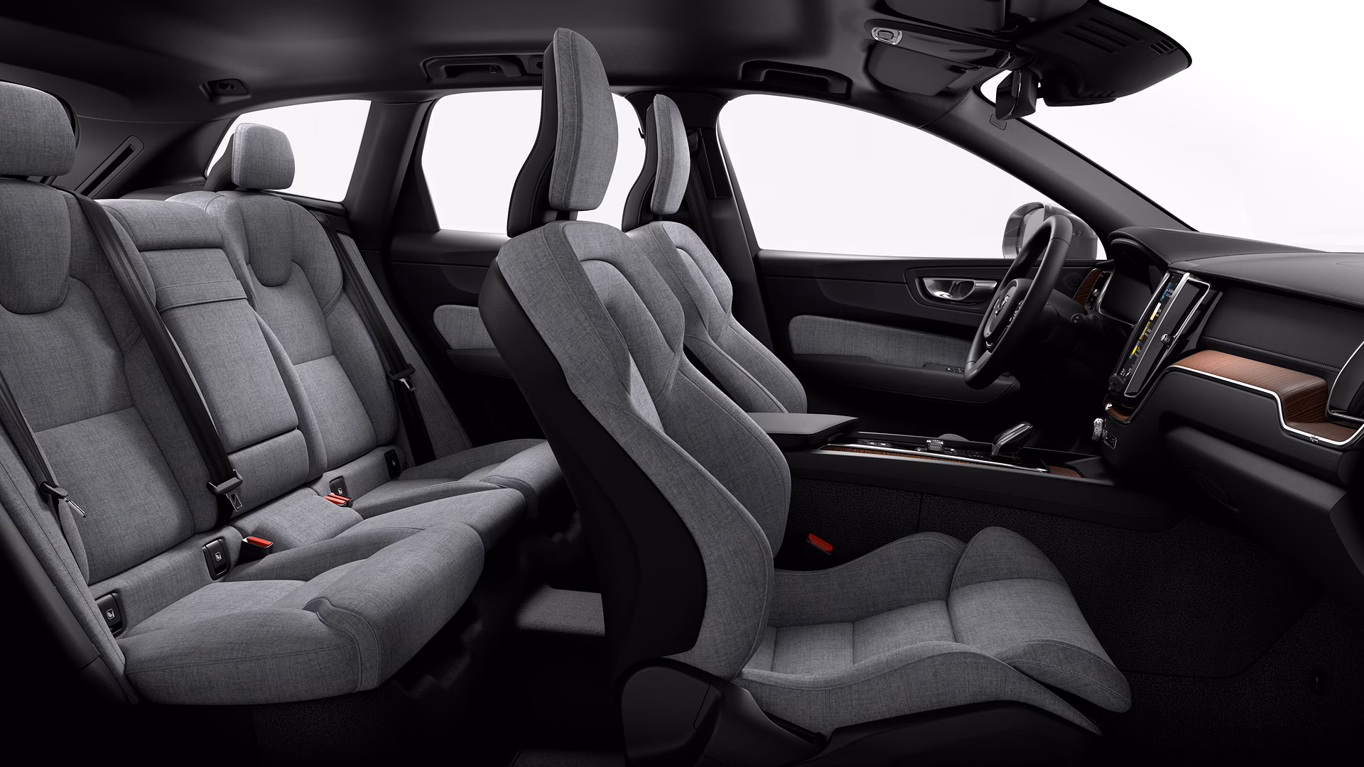 Вид салона автомобиля Volvo с сиденьями с серой тканью, современной приборной панелью и просторными креслами на пять человек.