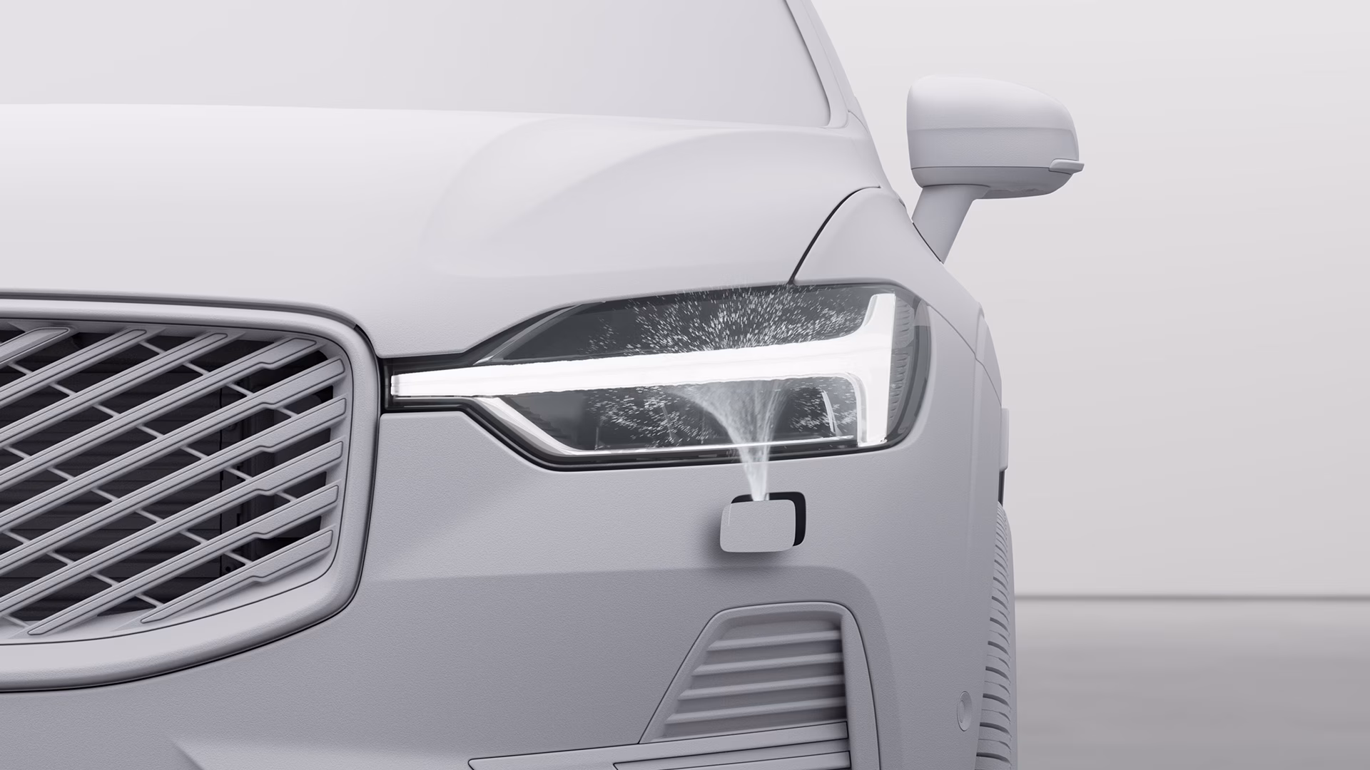 Крупный план фары автомобиля Volvo с работающей системой омывателей фар.