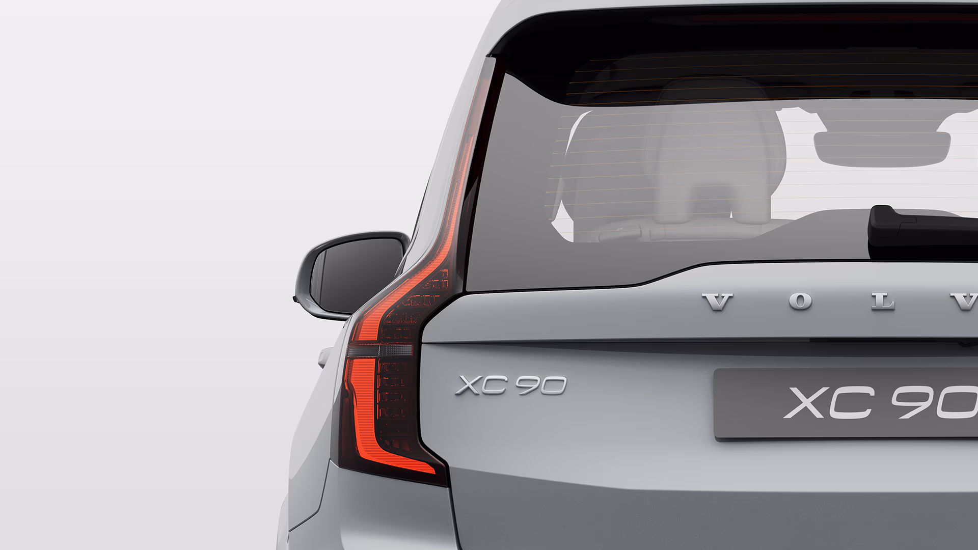 Крупный план задней части Volvo XC90, выделяющий значок модели и задний фонарь.