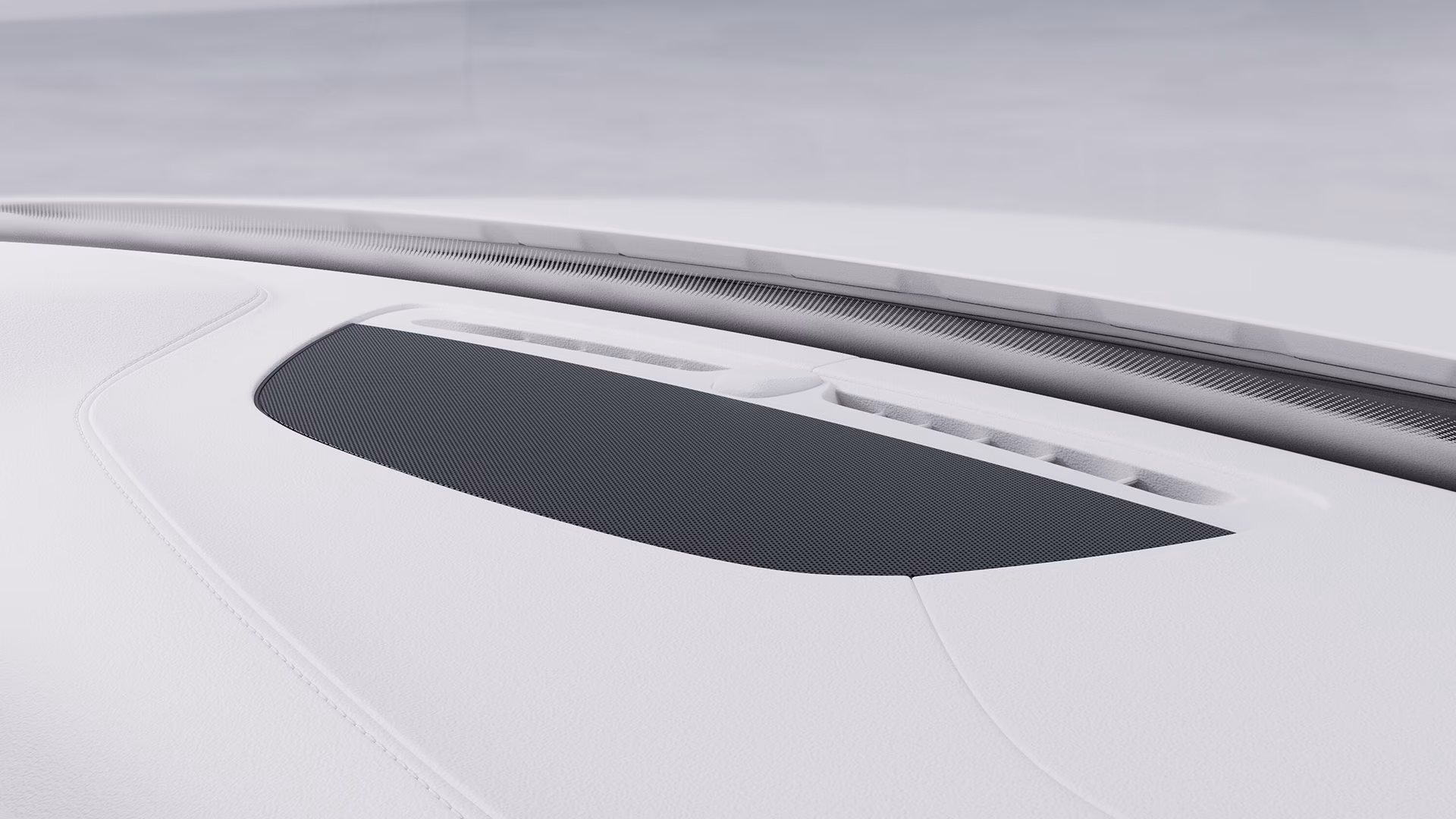 Крупный план приборной панели автомобиля Volvo с интегрированной в конструкцию решеткой динамика.