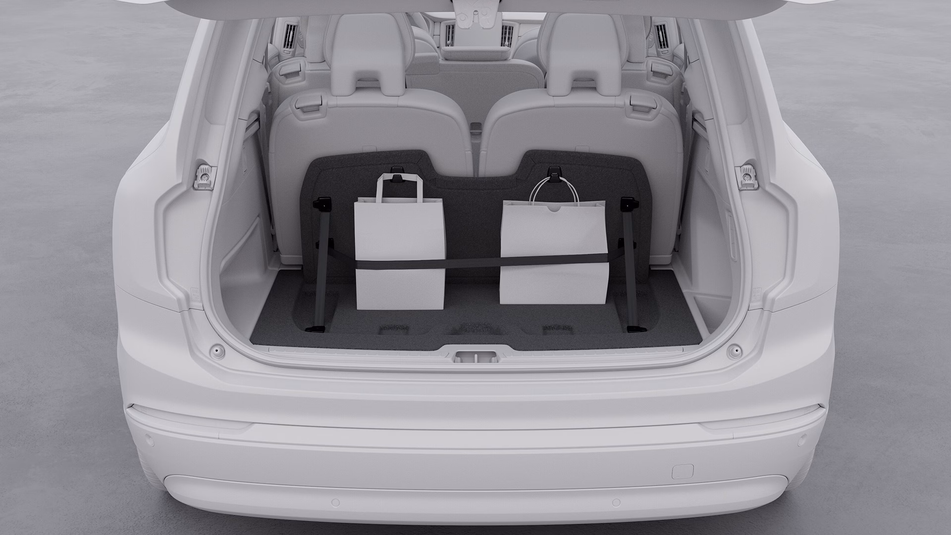 Вид на открытый багажник автомобиля Volvo, в котором установлены две сумки с покупками.