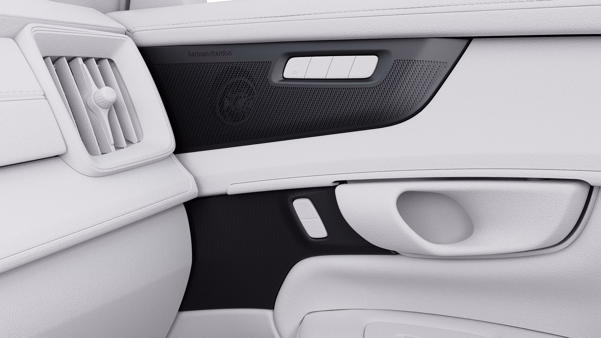 Крупный план внутренней дверной панели автомобиля Volvo с динамиком Harman Kardon, вентиляционным отверстием и дверной ручкой.