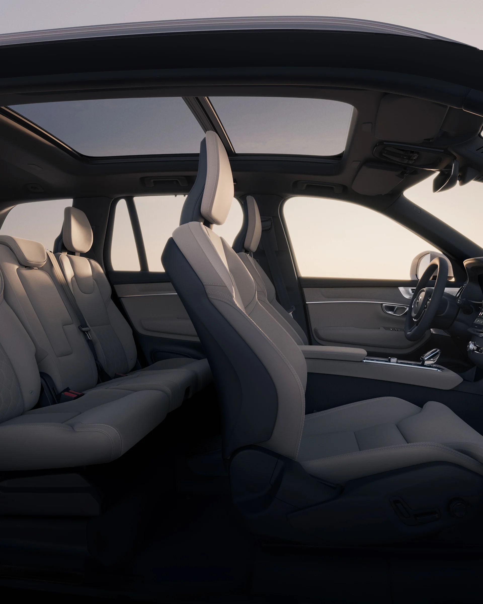 Открытый вид сбоку на просторный салон и панорамную крышу Volvo XC90.